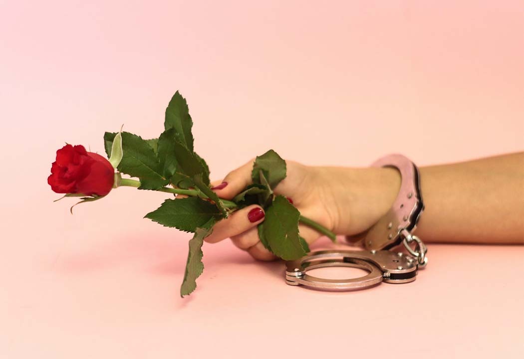 handcuffed woman holding rose